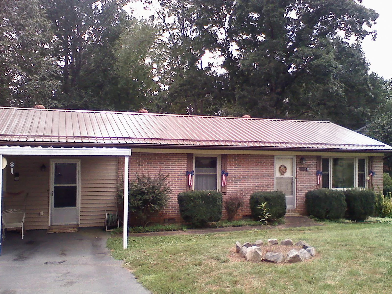 Bronze metal roof and carport on a brick ranch home — Roof Repair work by our crew in Daytona Beach